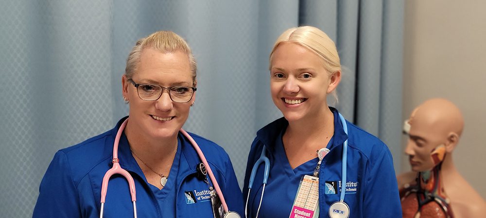 Two women with stethoscopes around their necks smiling