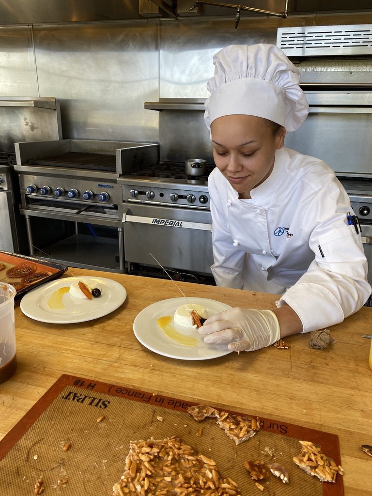 Culinary student finishing a dessert plate