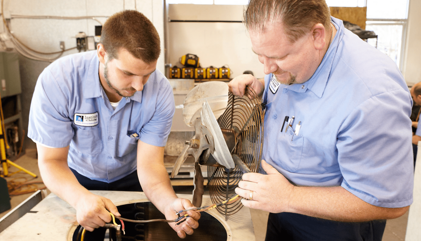 Two men examining fan wiring