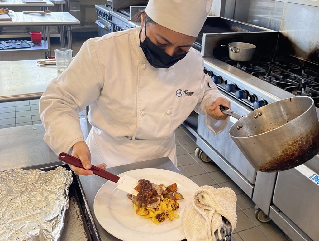 Culinary student plates a meal