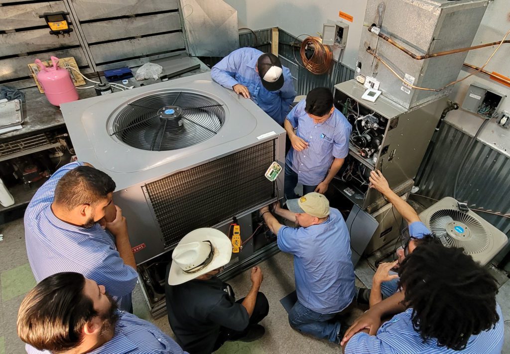 Students standing around an air conditioning unit
