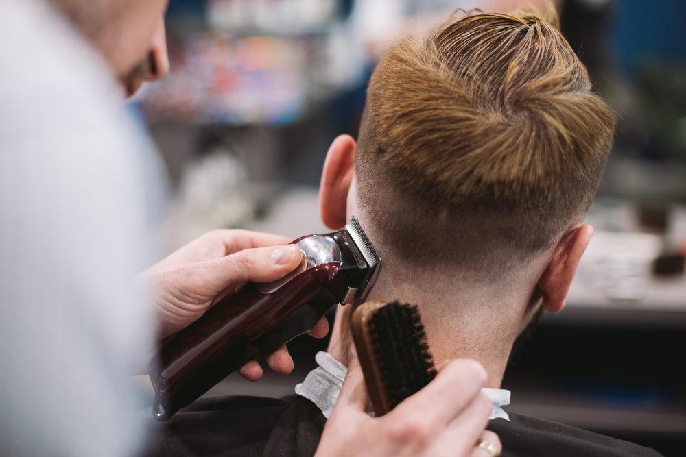 Barber shaving the back of a person's head