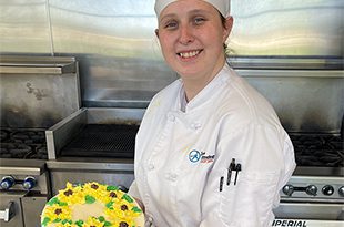 Girl smiling holding a decorated cake